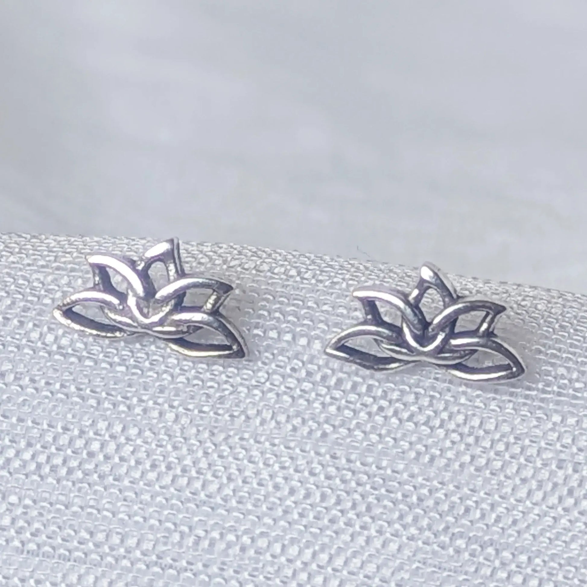 Detailreiche Nahaufnahme der Lotus Ohrstecker aus 925 Sterling Silber mit filigranem Cut-Out-Design.