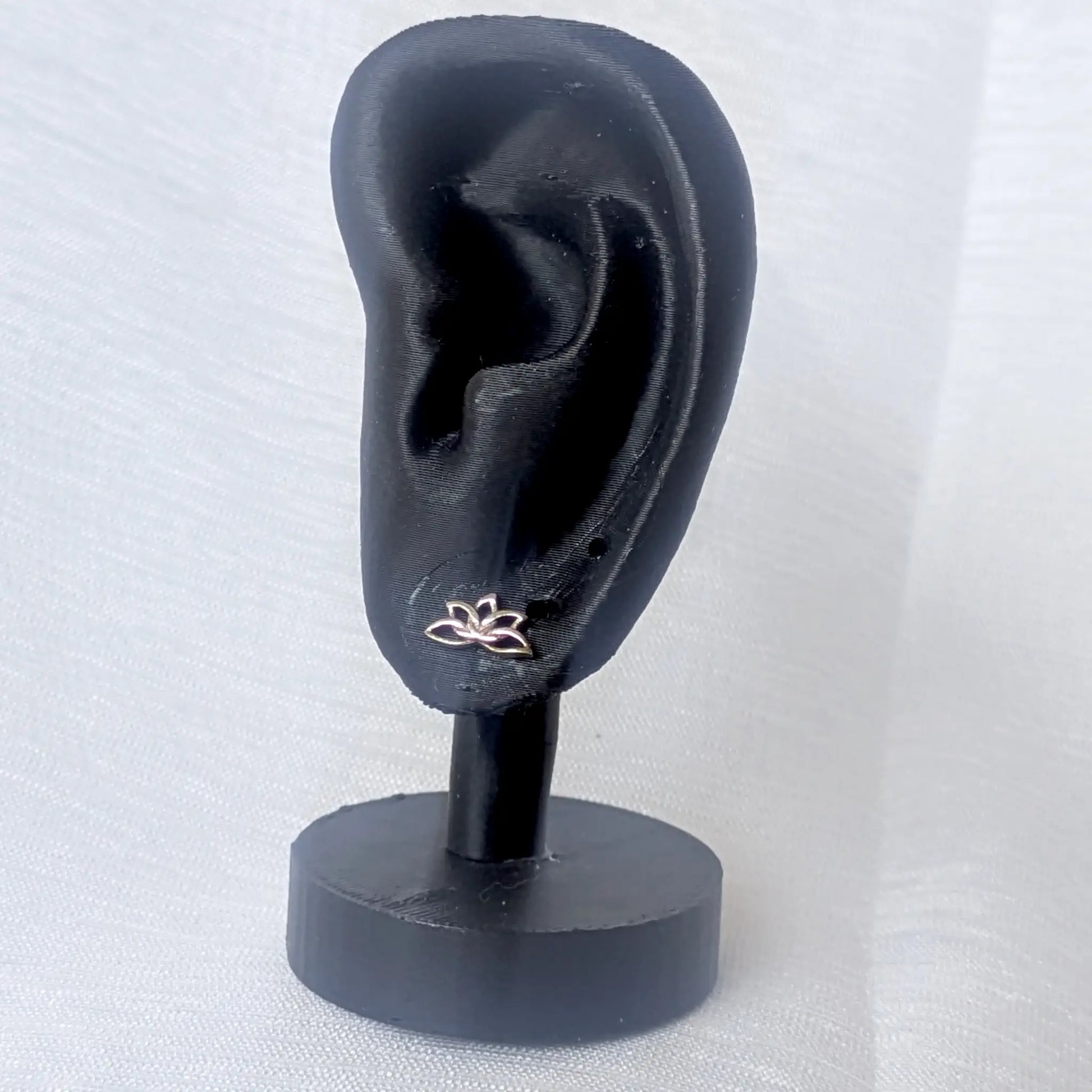 Filigrane Lotus Ohrstecker aus 925 Silber getragen am schwarzen Ohr-Display zur Veranschaulichung der Proportionalität.