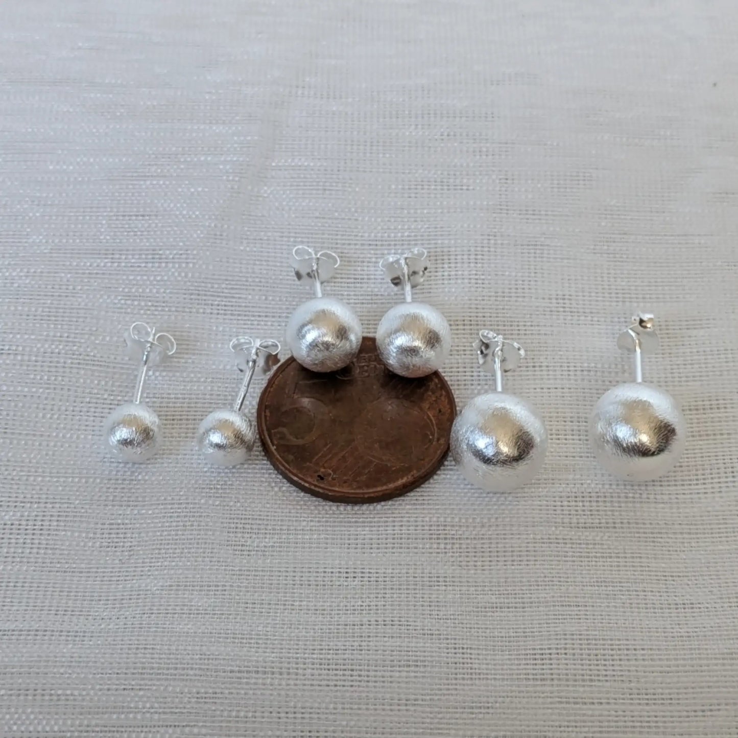 Größenvergleich der 925 Silber Kugelohrringe neben einer 5-Cent-Münze.
