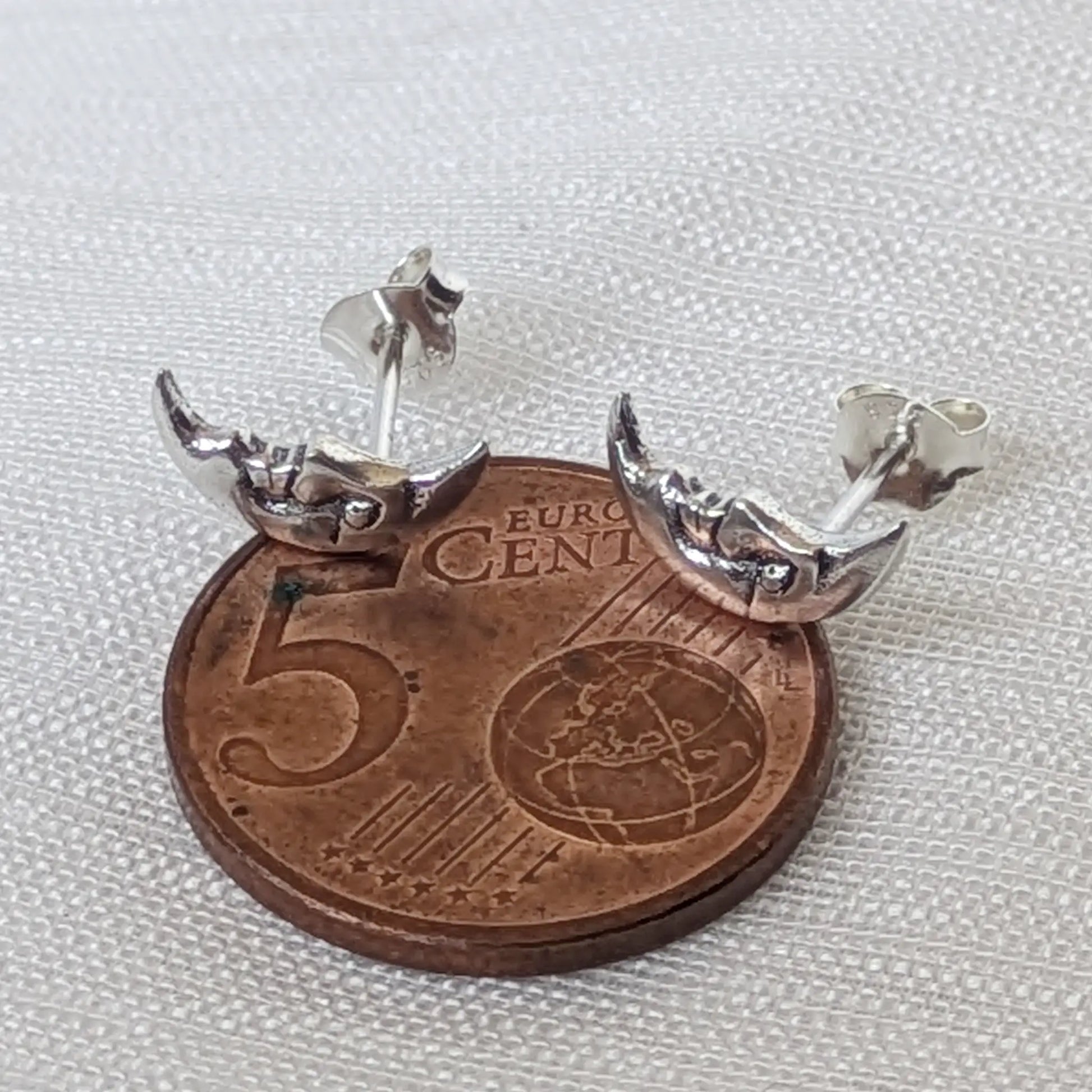 Direkter Größenvergleich der detailreichen Halbmodmond-Ohrringe aus 925er Silber platziert auf einer 5-Cent-Münze.