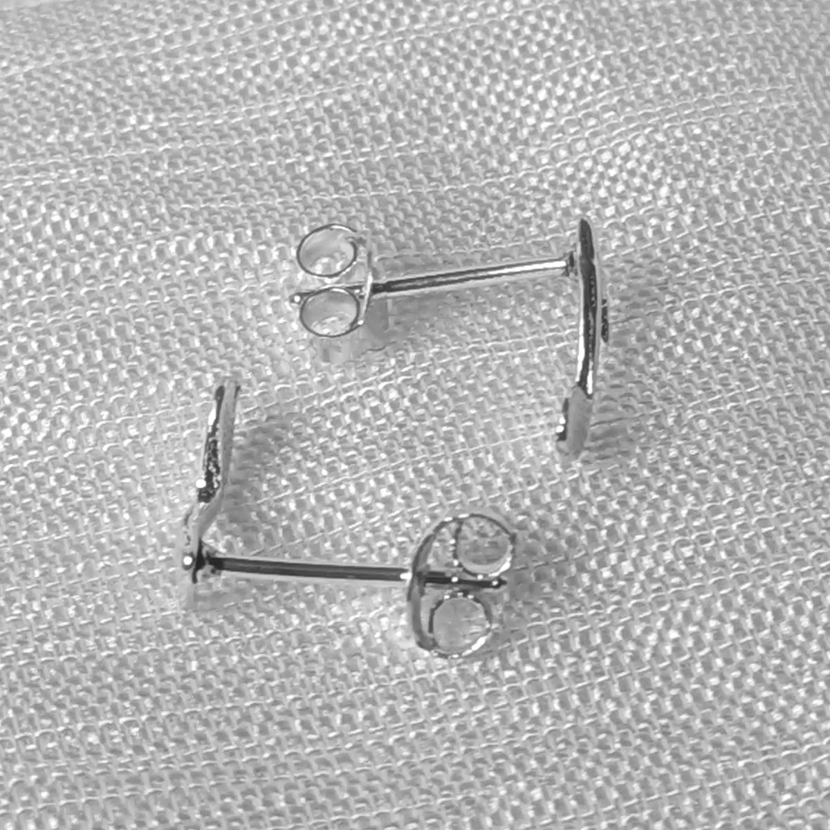 Seitenansicht der flachen 925 Silber Musiknoten-Ohrstecker mit eng anliegendem Profil.