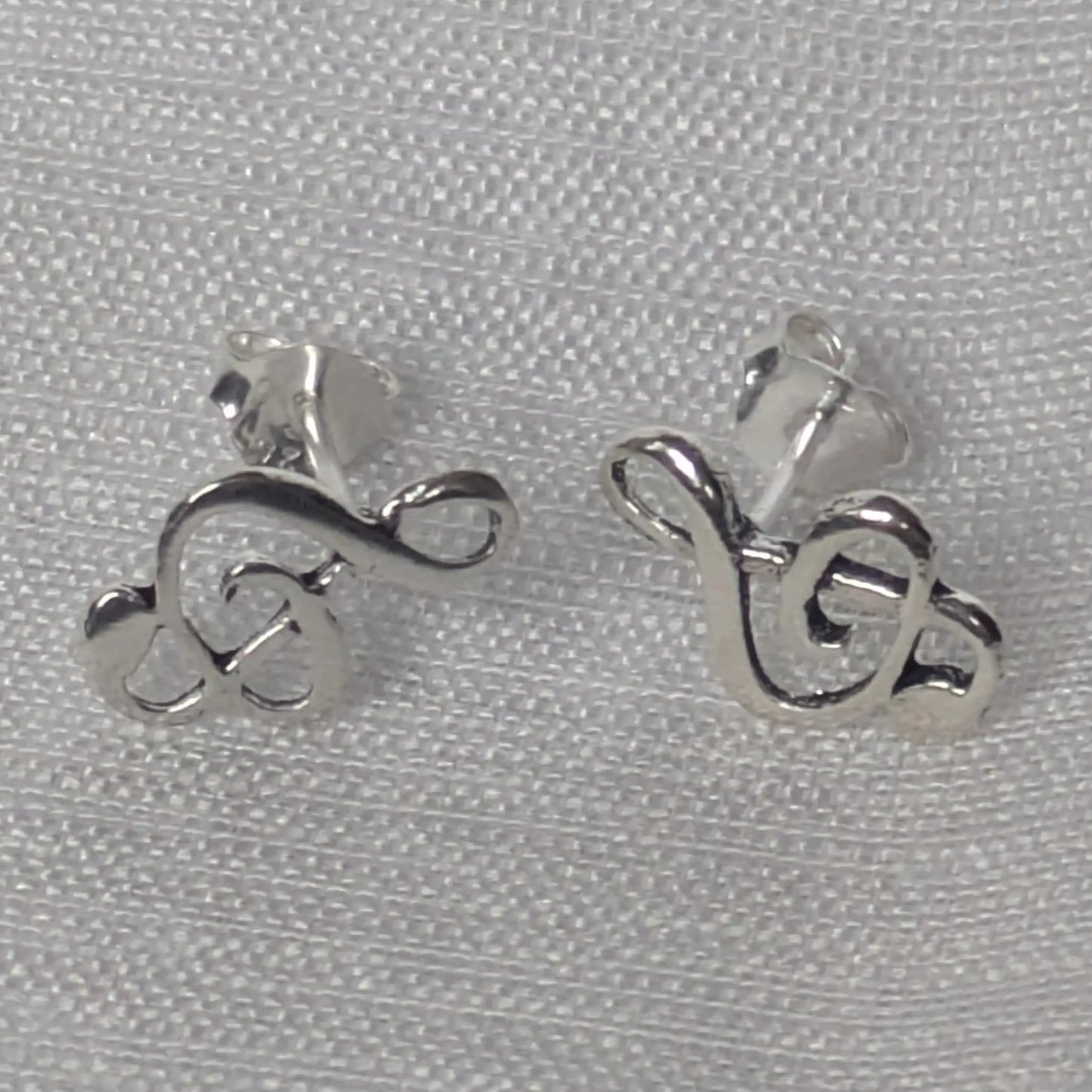 Paar silberne Musik-Ohrstecker in Violinschlüssel-Form in der Vorderansicht.