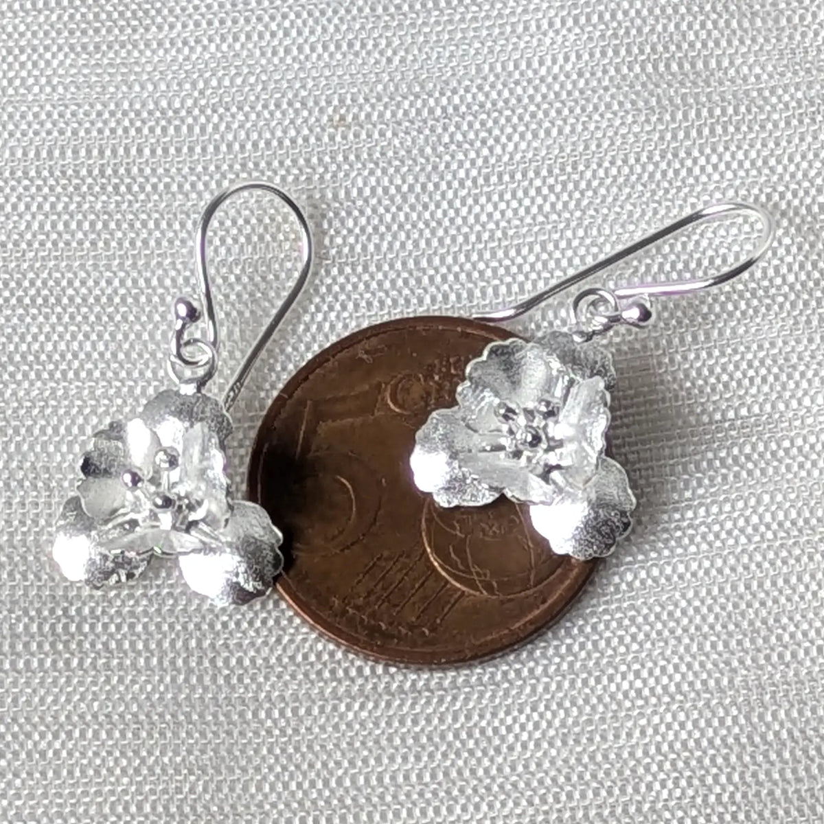 Größenvergleich der filigranen Silber-Blüten-Ohrhänger liegend auf einer 5-Cent-Münze.