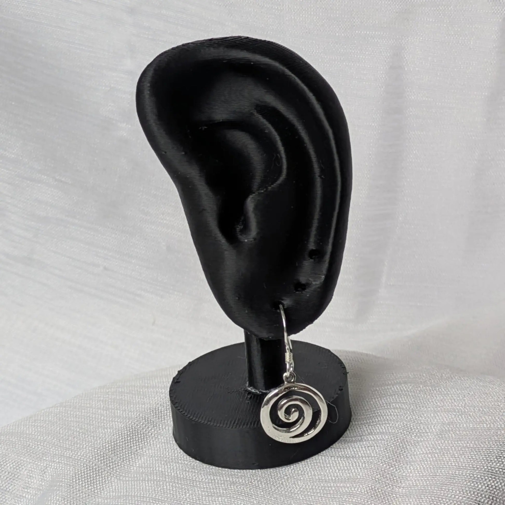 Elegante Präsentation der Spiral-Ohrringe an einem schwarzen Schmuckhalter.