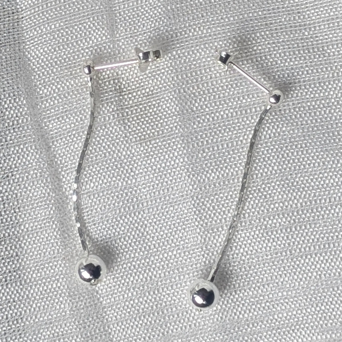 Frontalansicht von langen 925 Silber Ohrsteckern mit feiner Kette und glänzenden Kugelenden