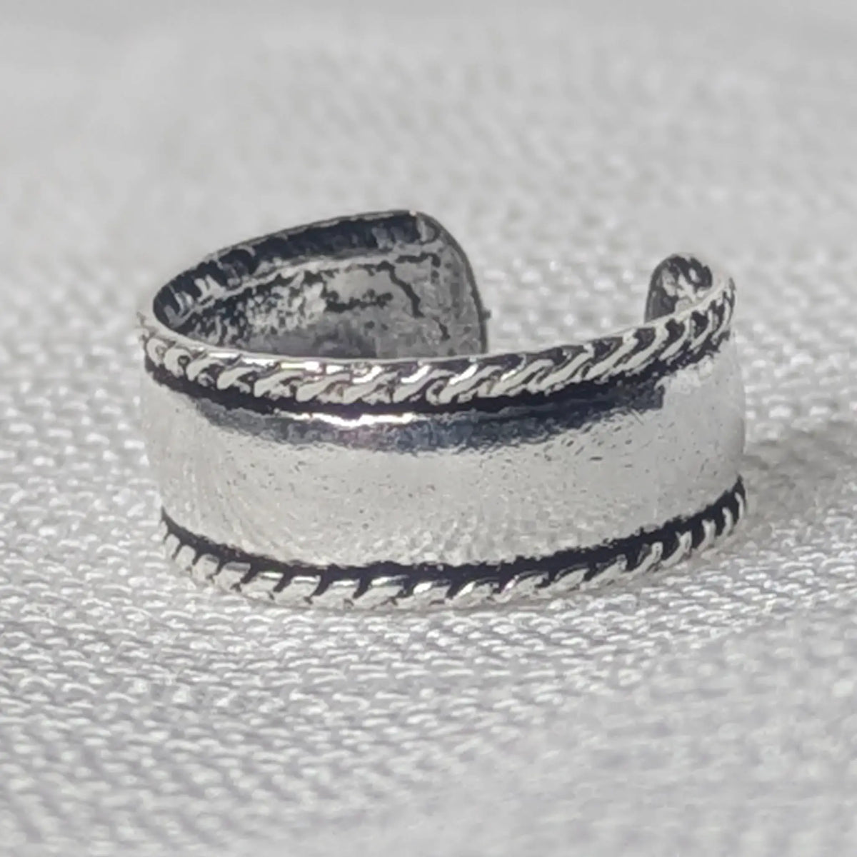 Nahaufnahme einer breiten 925 Silber Ohrklemme mit glatter Mitte und geschwärztem Kordelrand im Vintage-Stil.