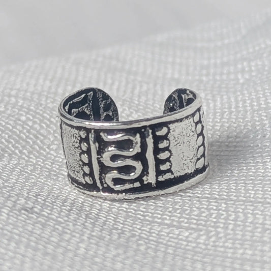 Nahaufnahme eines breiten 925 Silber Ear Cuffs mit geschwärztem Antik-Finish und verziertem S-Muster.