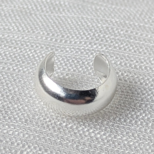 Detaillierte Nahaufnahme einer breiten, glänzend polierten Earcuff aus 925 Silber in minimalistischem Design.
