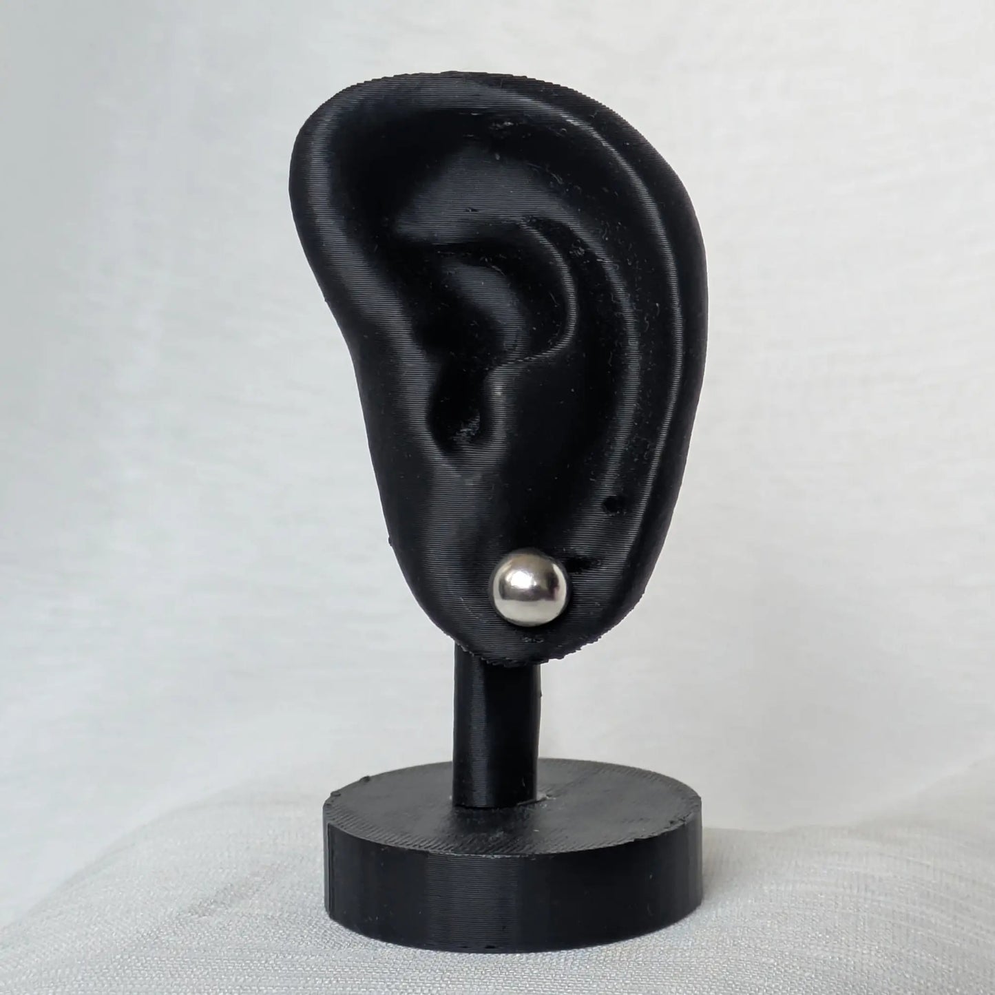 8mm Halbkugel Ohrstecker Silber am schwarzen Ohr-Modell präsentiert.