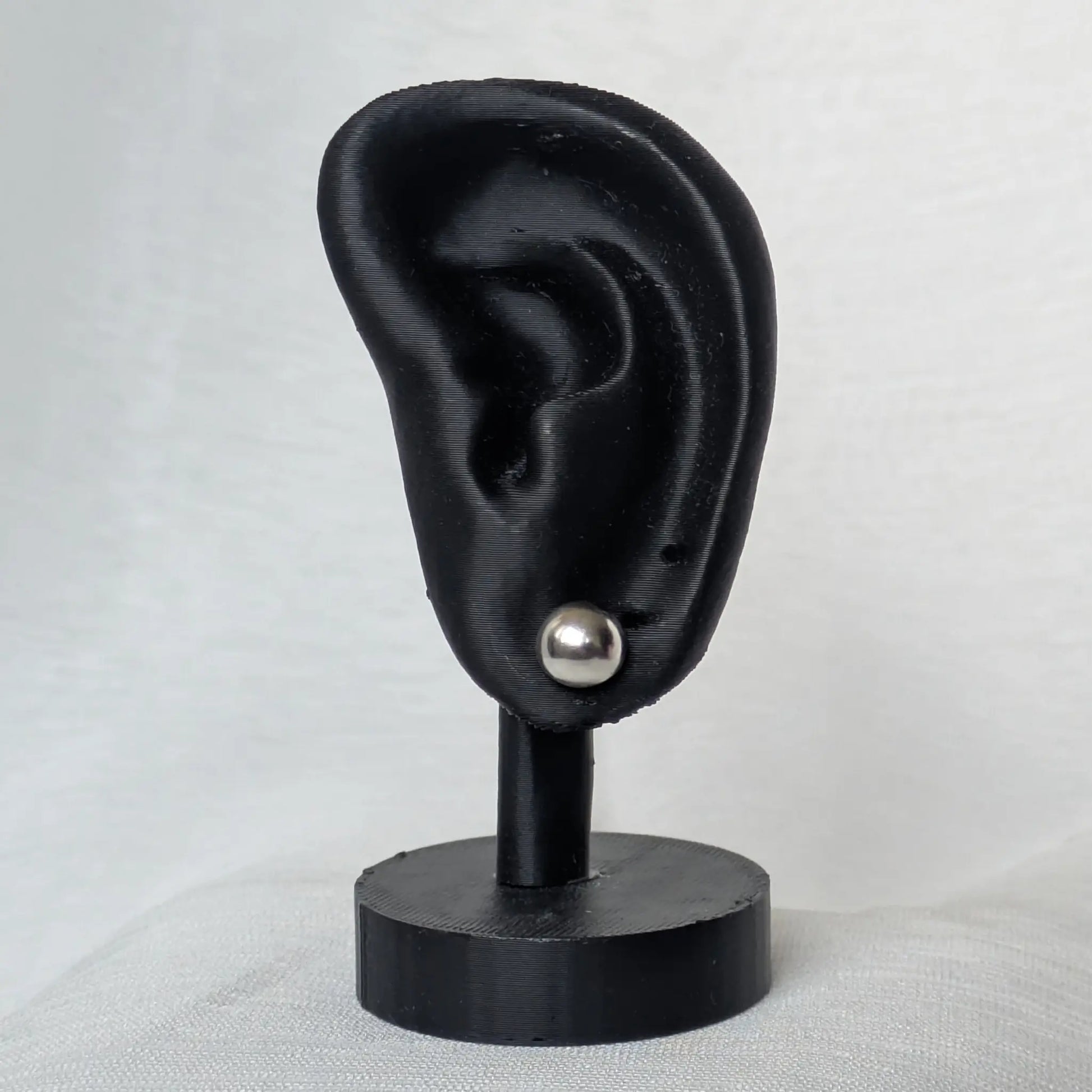 8mm Halbkugel Ohrstecker Silber am schwarzen Ohr-Modell präsentiert.