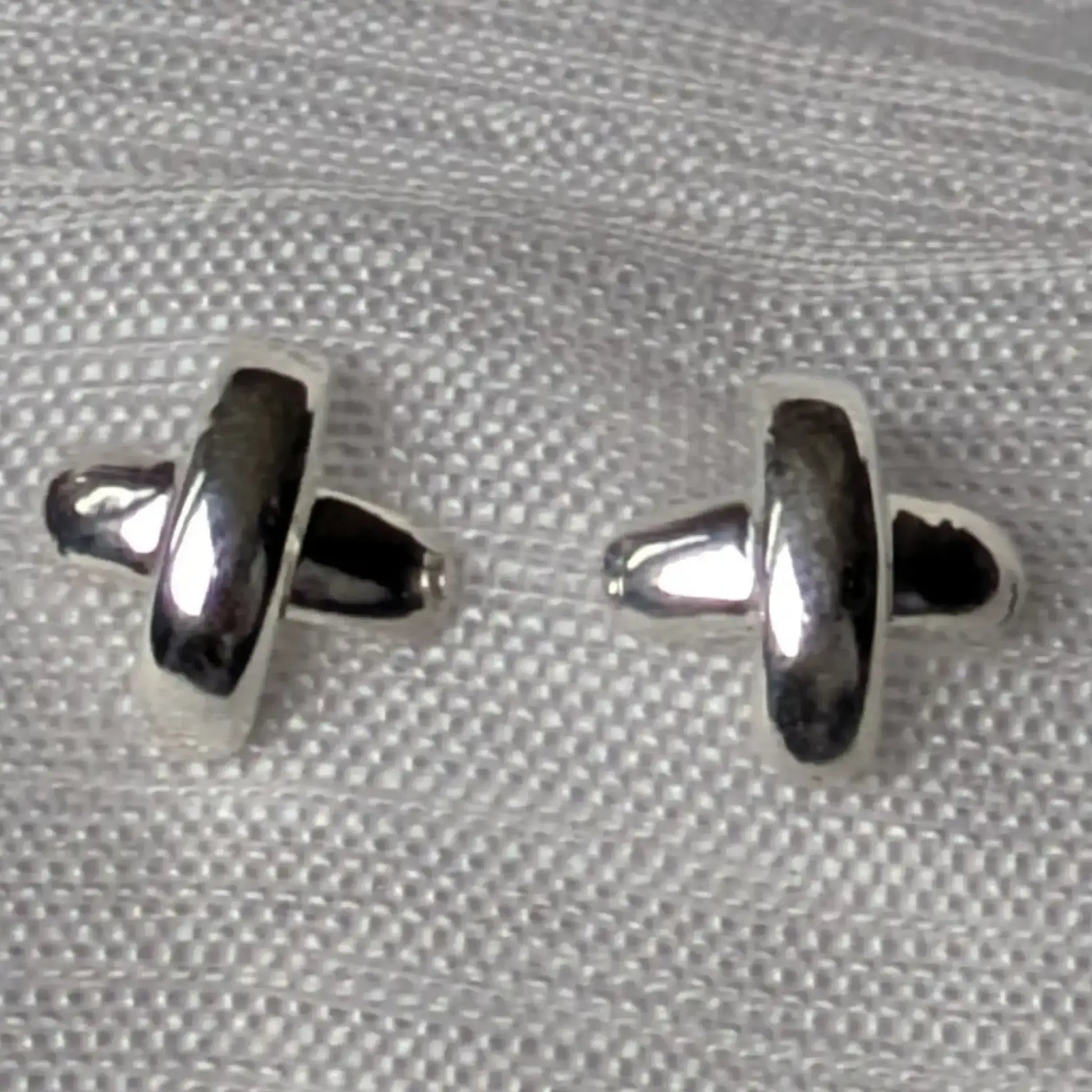 Detailansicht der polierten Oberfläche der 925 Silber Kreuz-Ohrstecker.