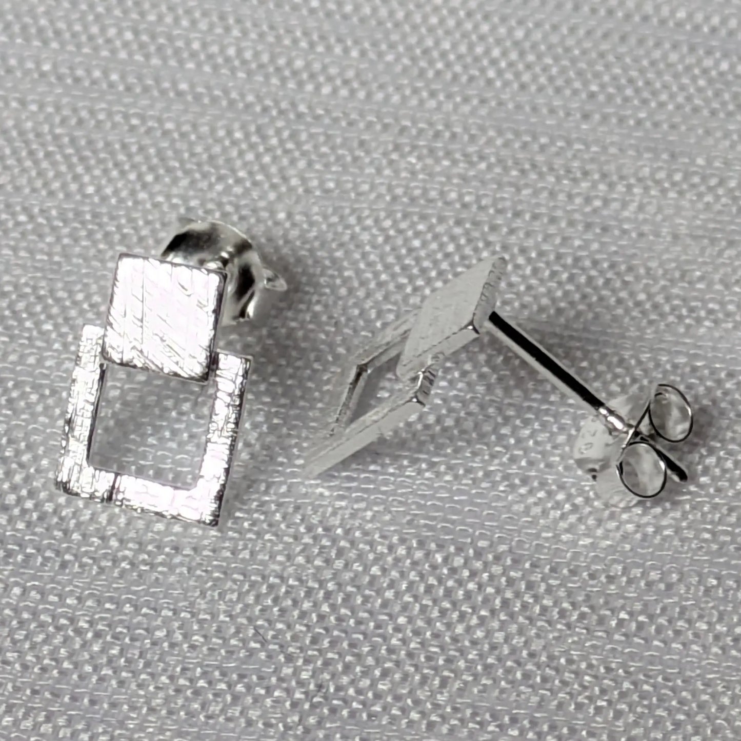 Seitenprofil der silbernen Ohrstecker zur Darstellung der Materialstärke und Struktur.