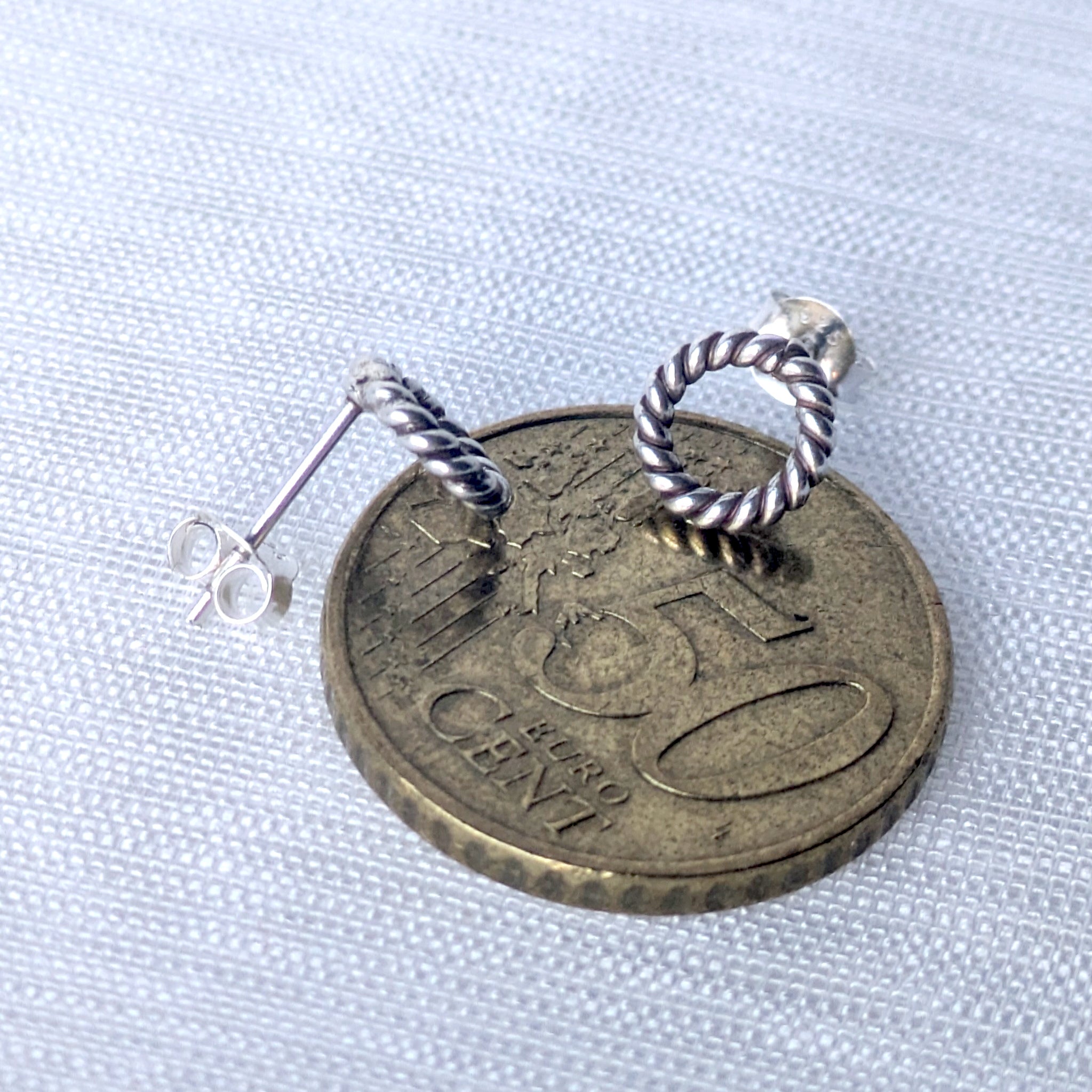 Silberne Ohrstecker mit gedrehtem Kreis-Design auf 50-Cent Münze