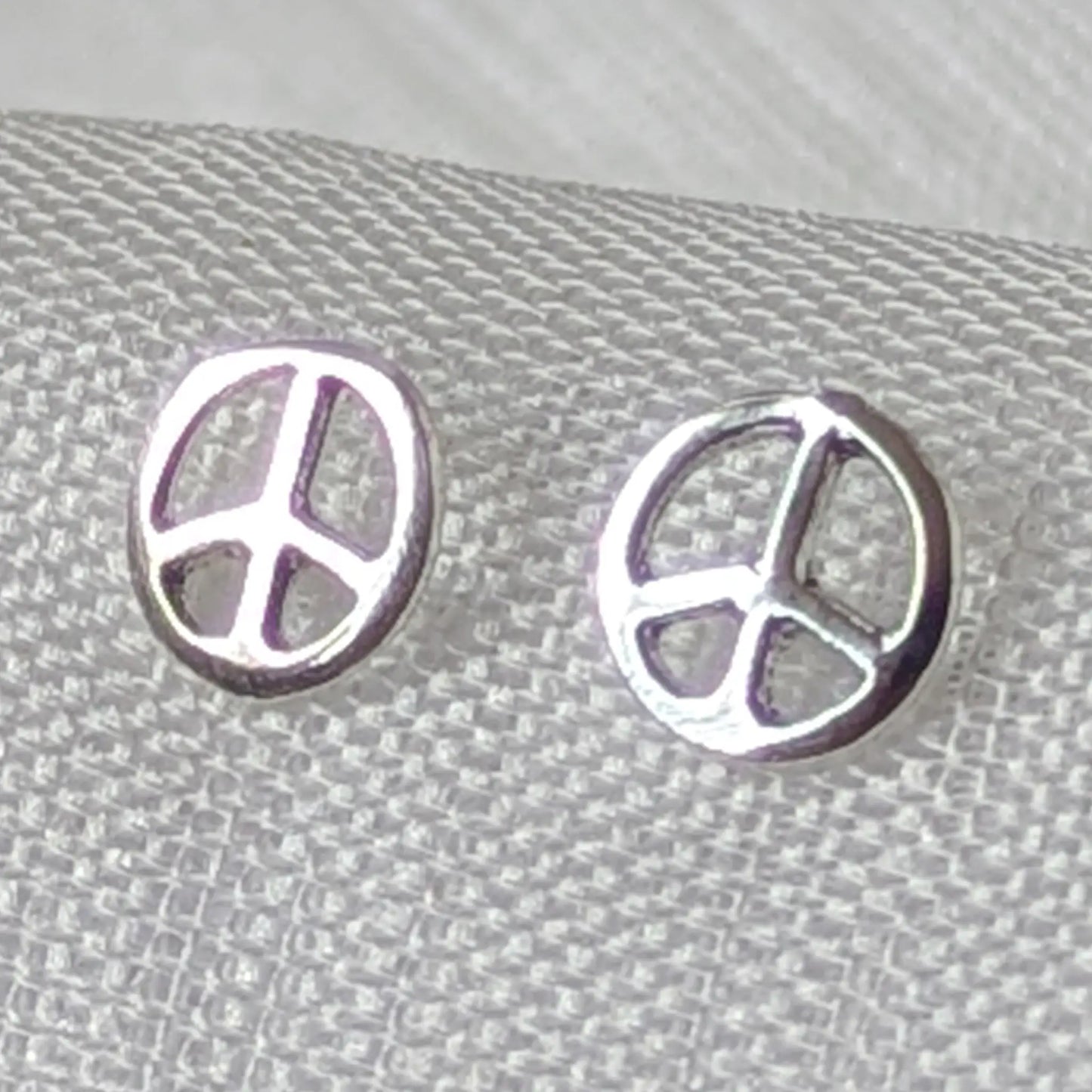 Nahaufnahme der filigranen Peace Zeichen Ohrstecker aus hochglanzpoliertem 925 Sterling Silber
