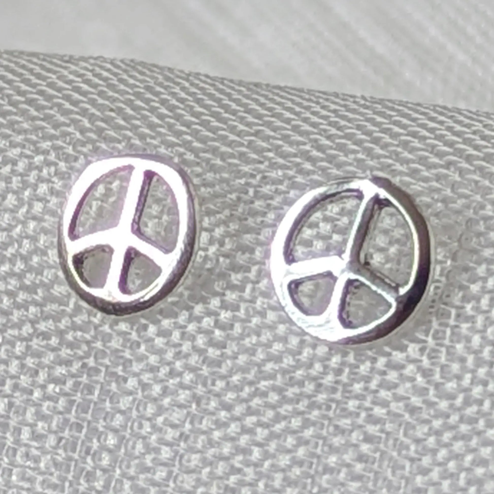Nahaufnahme der filigranen Peace Zeichen Ohrstecker aus hochglanzpoliertem 925 Sterling Silber