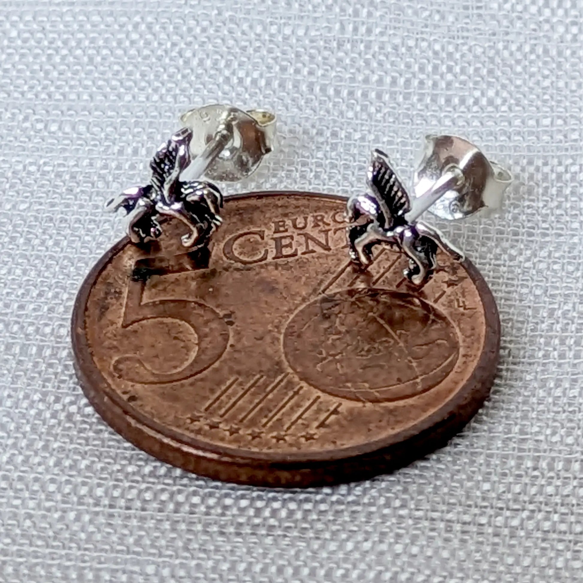 Geflügeltes Pferd Pegasus Ohrstecker aus 925 Silber im Größenvergleich auf 5-Cent-Münze