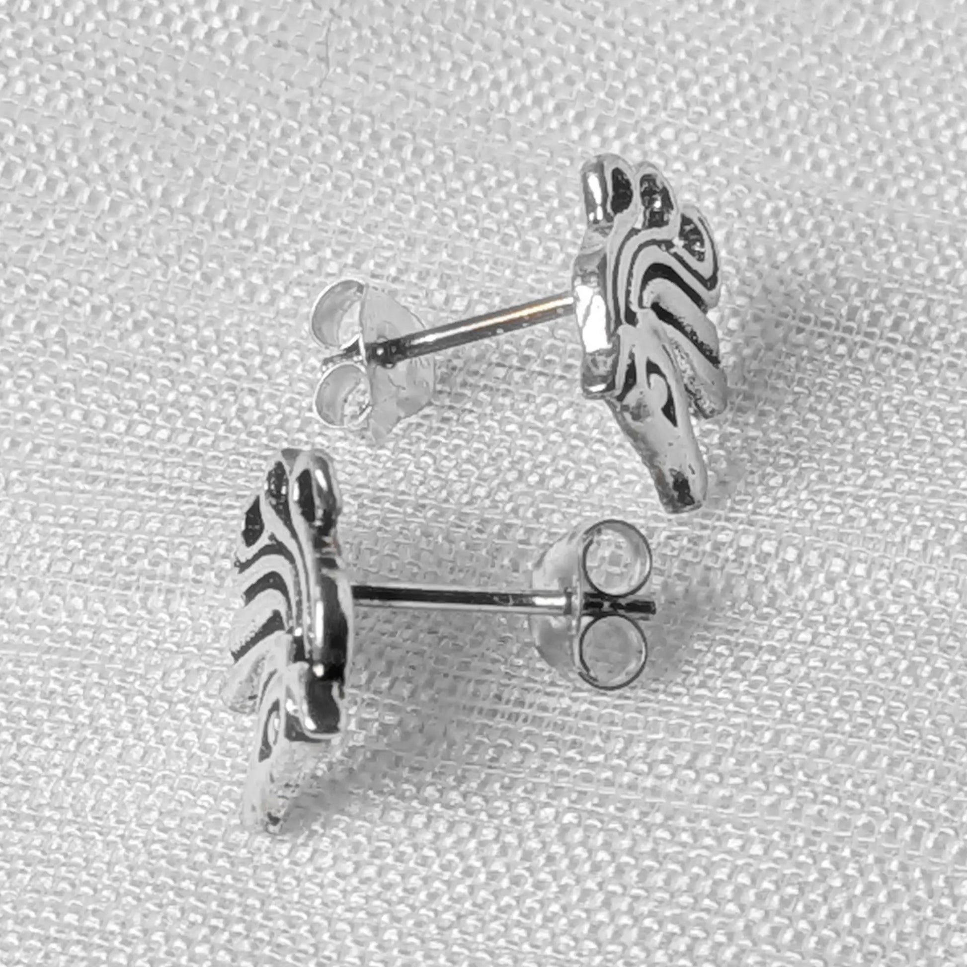 Seitenansicht der flachen Pferde-Ohrstecker aus 925 Silber am Ohrläppchen.