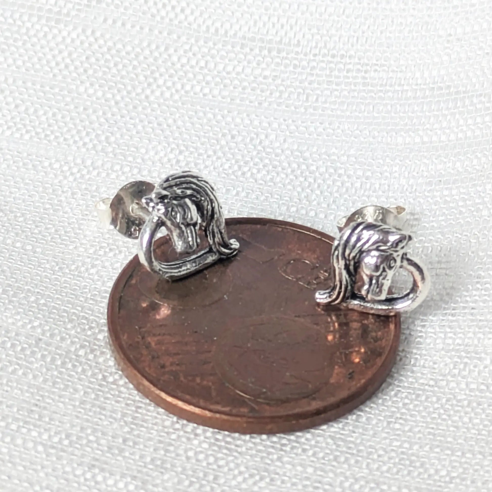 Größenvergleich Pferdeohrringe Silber auf einer 5-Cent-Münze.