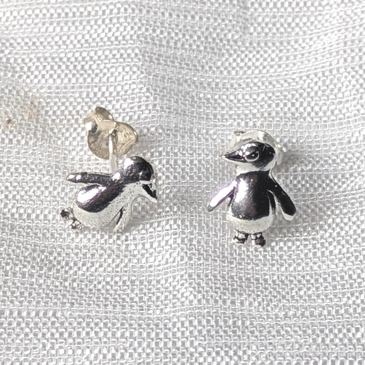 Frontalansicht der niedlichen Pinguin-Ohrstecker aus 925 Sterlingsilber, die die glatten, abgerundeten Körperkonturen zeigen.