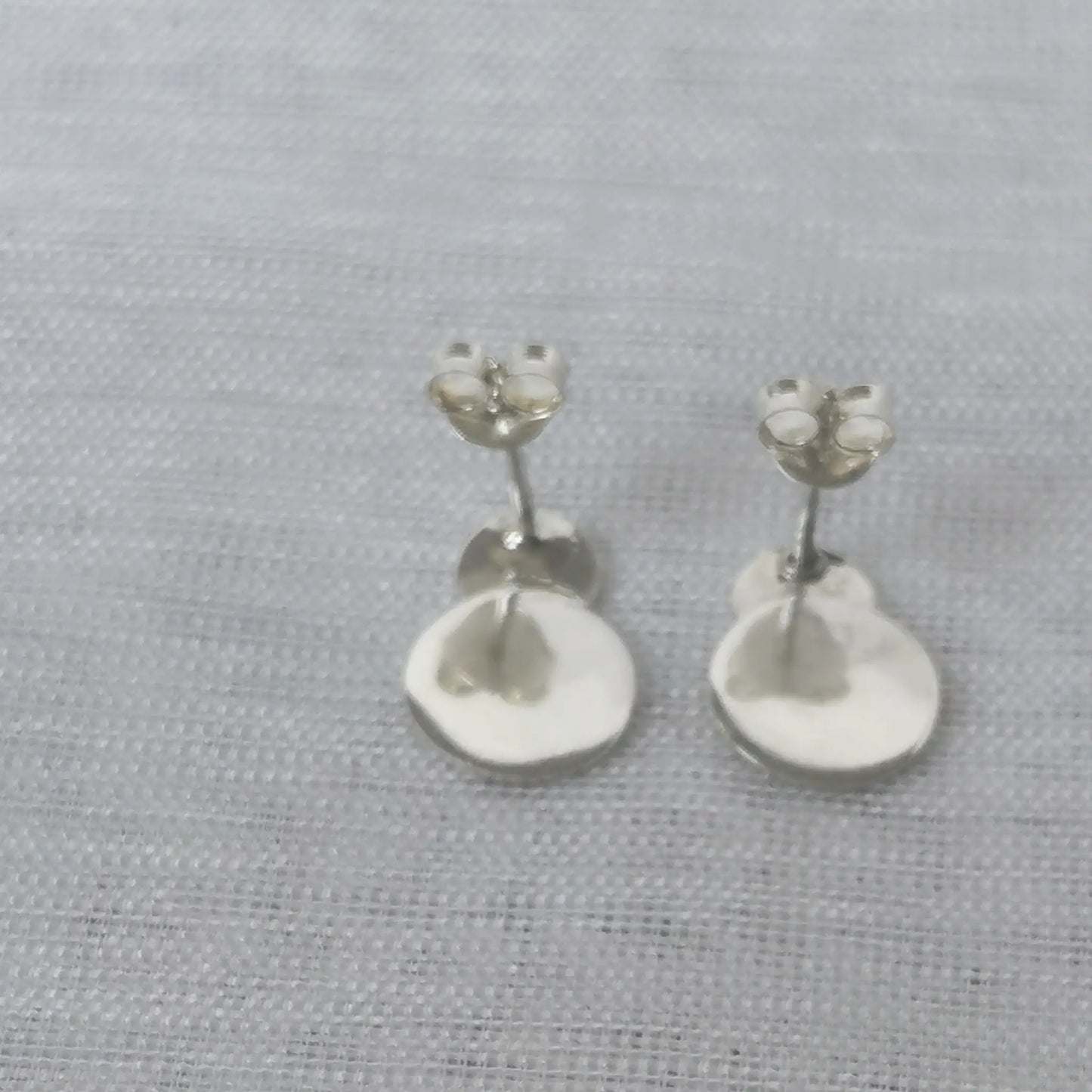 Rückseite der geometrischen Plättchen-Ohrringe aus Silber mit angebrachten Schmetterlingsverschlüssen für sicheren Halt.