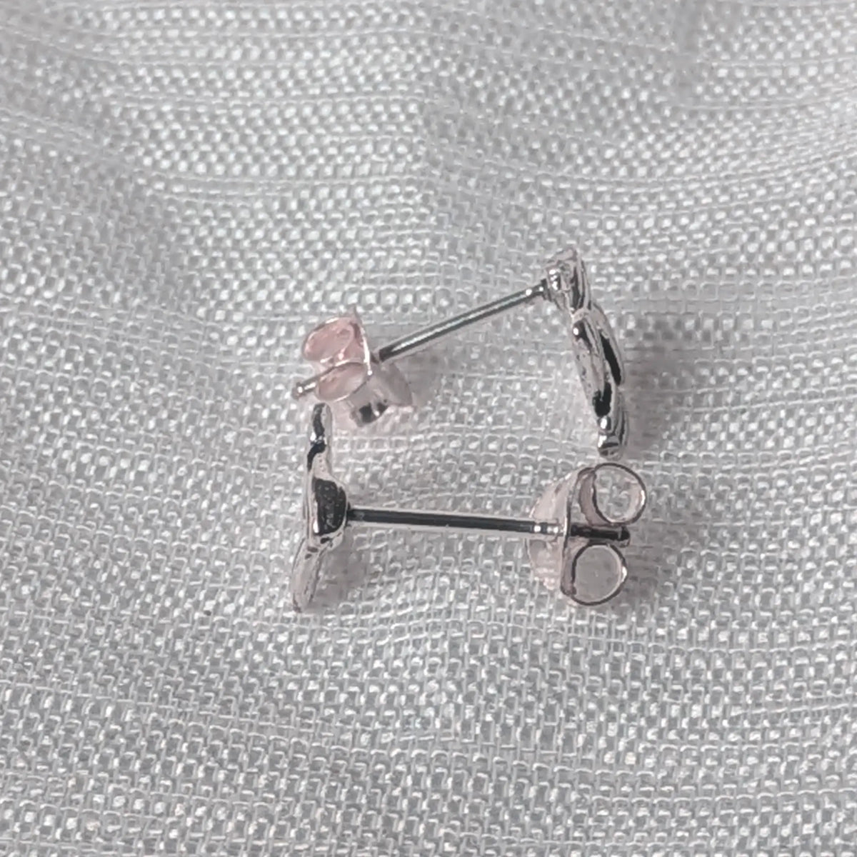 Seitenansicht der quadratischen Knoten-Silberohrstecker mit Fokus auf den feinen Profilaufbau und den Steckerstift.