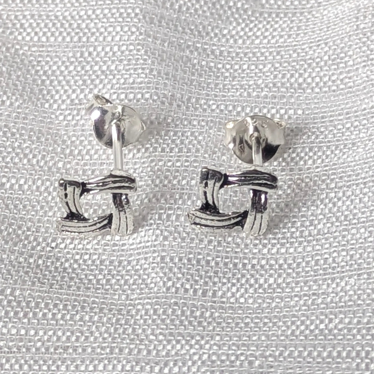 Frontalansicht der eckigen Ohrstecker aus 925 Sterlingsilber mit plastischem Flechtmuster.