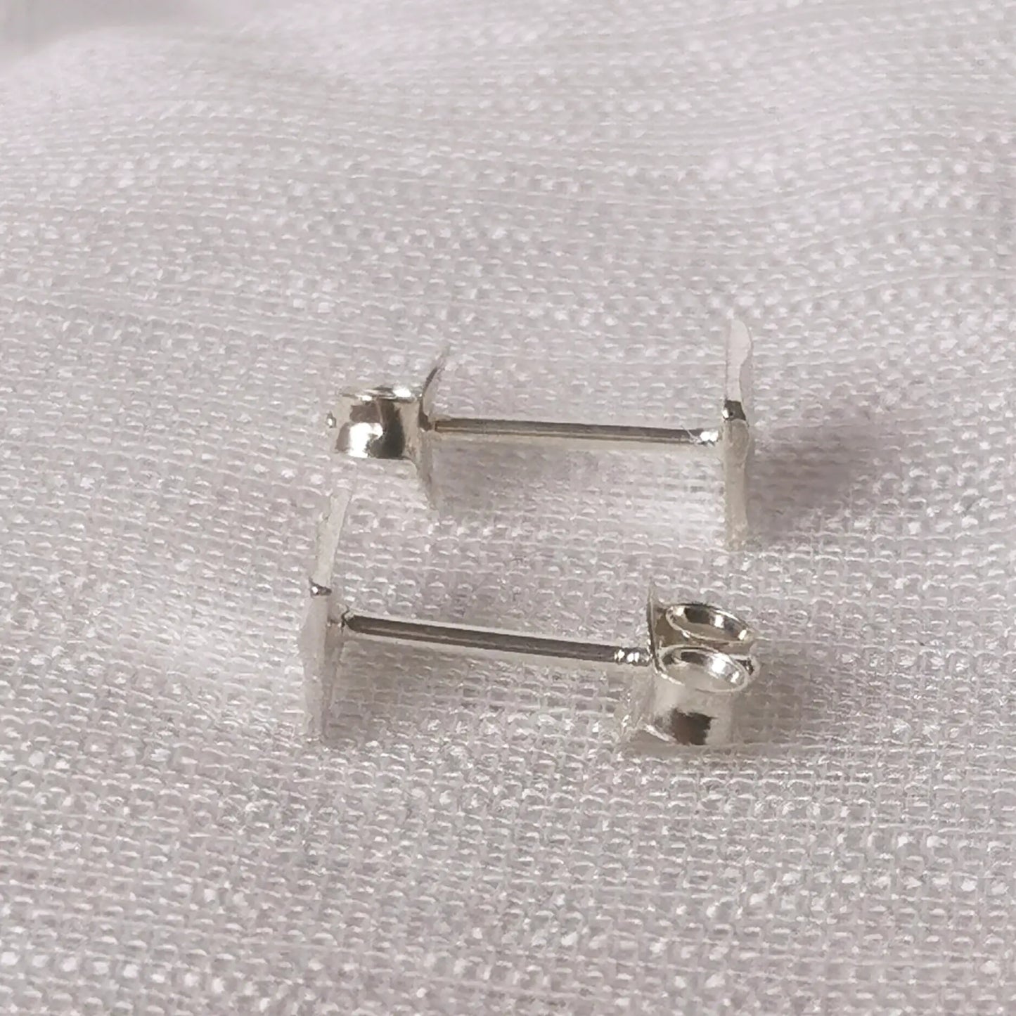 Seitliche Perspektive der quadratischen Silber-Ohrstecker zeigt die flache Form und die Position des Stecker-Stifts.