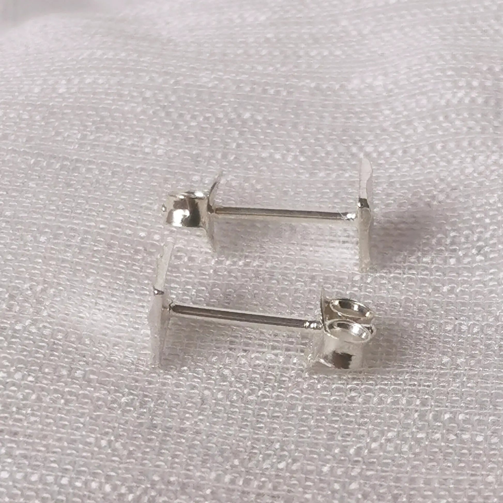 Seitliche Perspektive der quadratischen Silber-Ohrstecker zeigt die flache Form und die Position des Stecker-Stifts.