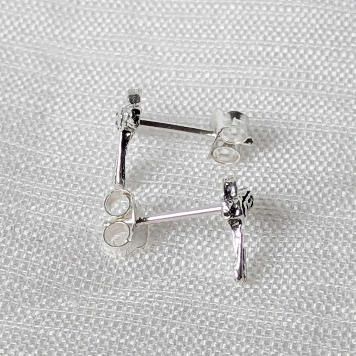 Seitenansicht der Silber-Ohrstecker im Barber-Motiv mit angelötetem Stift für sicheren Halt im Ohrläppchen.