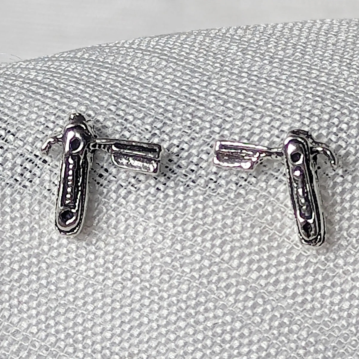 Nahaufnahme von zwei 925 Silber Ohrsteckern, detailliert geformt als aufgeklappte Rasiermesser im Vintage-Stil.