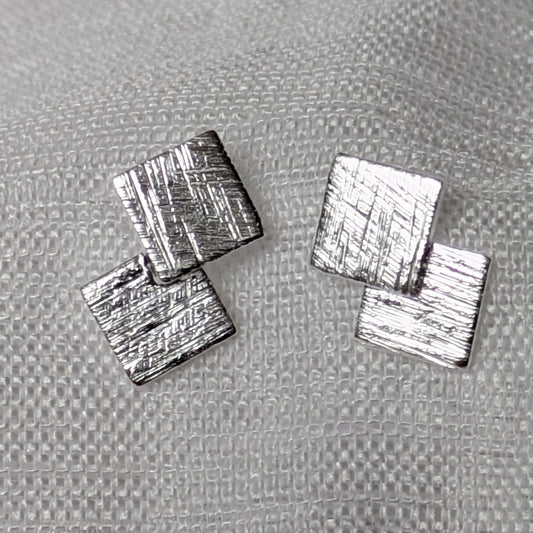 Detailansicht der eiskratz-mattierten Oberflächenstruktur der quadratischen Silber-Ohrstecker.