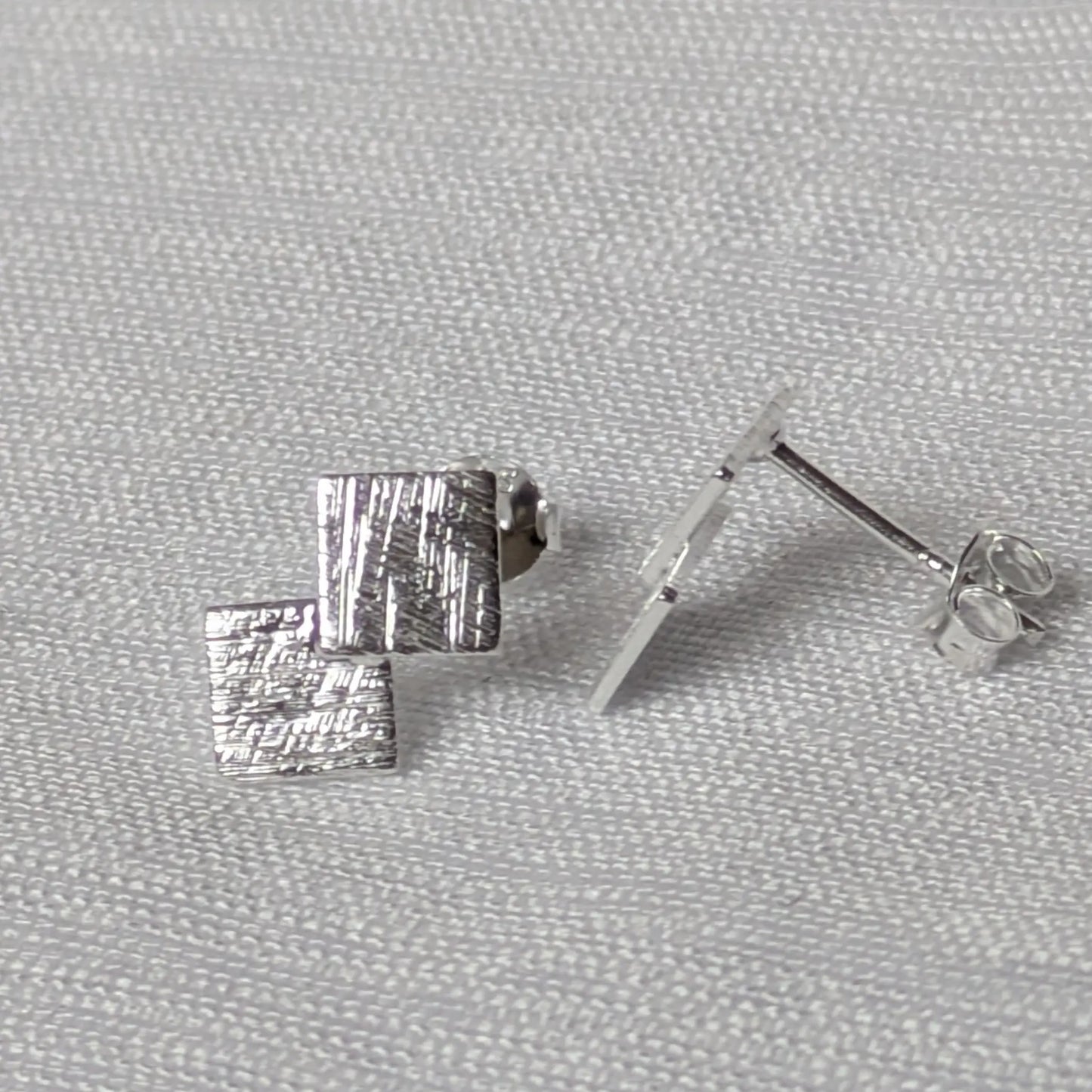 Seitenprofil der flachen, geometrischen Silberstecker mit Fokus auf den Stecker-Stift.