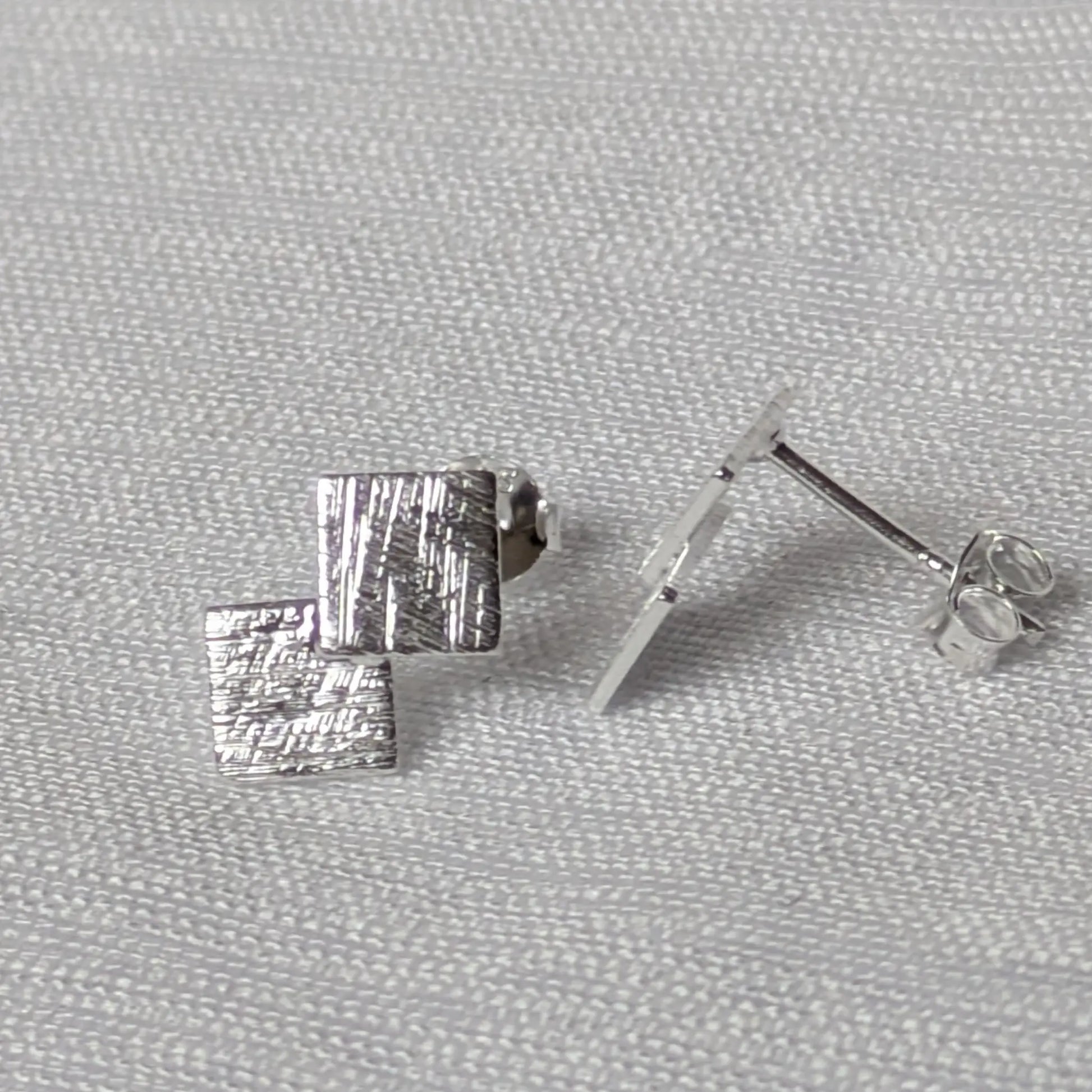 Seitenprofil der flachen, geometrischen Silberstecker mit Fokus auf den Stecker-Stift.