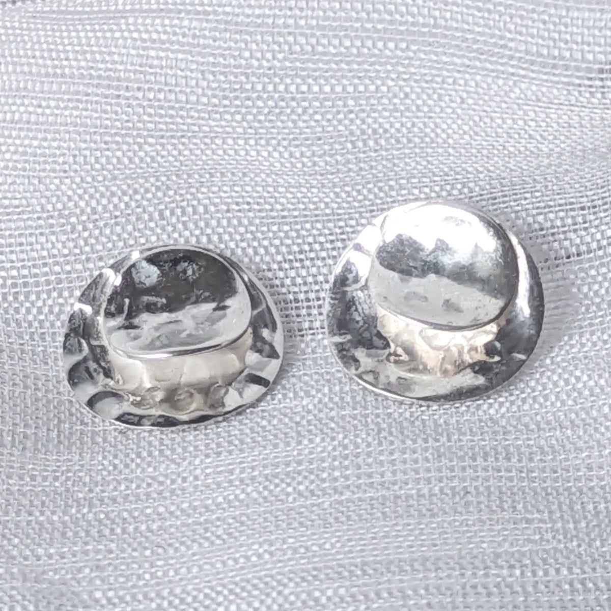 Nahaufnahme der runden 925 Silber Ohrstecker mit glänzender Wölbung und gehämmertem Rand