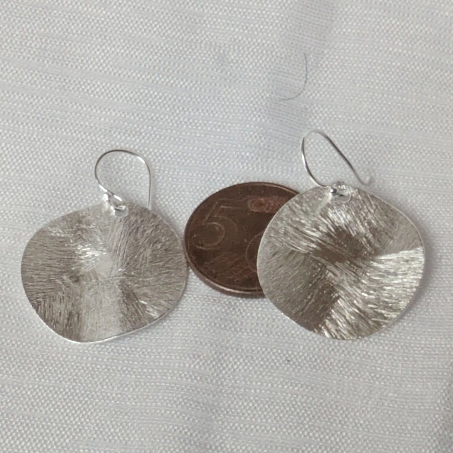 Größenvergleich der runden Silber-Plättchen mit einer 5-Cent-Münze