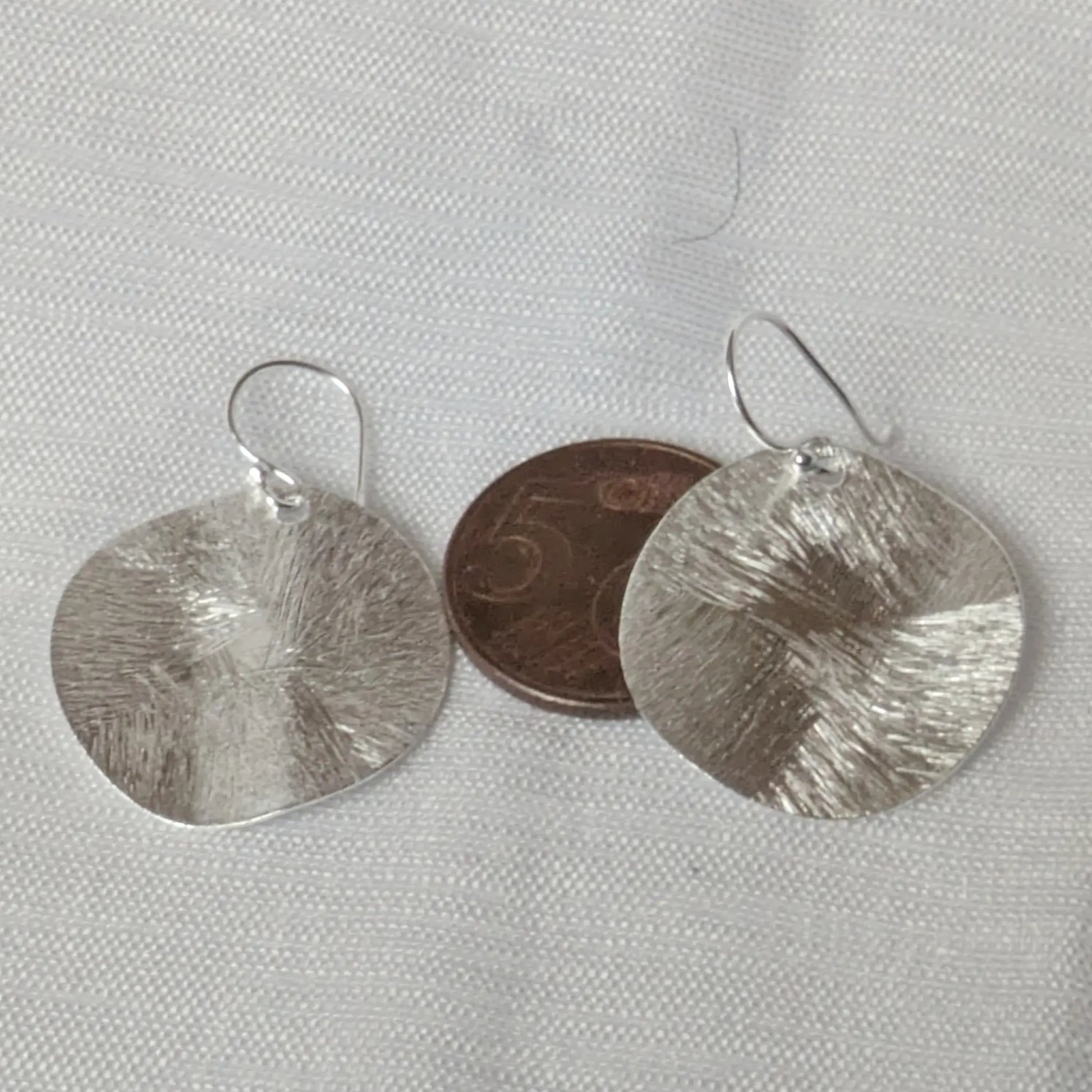Größenvergleich der runden Silber-Plättchen mit einer 5-Cent-Münze