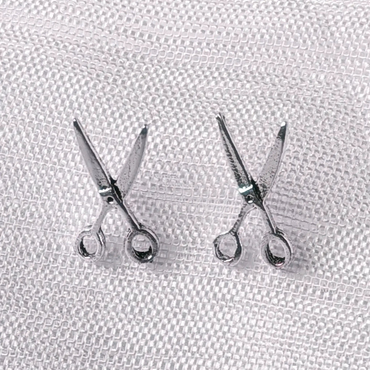 Detaillierte Nahaufnahme von 925 Silber Ohrsteckern in Form einer geöffneten Schere.