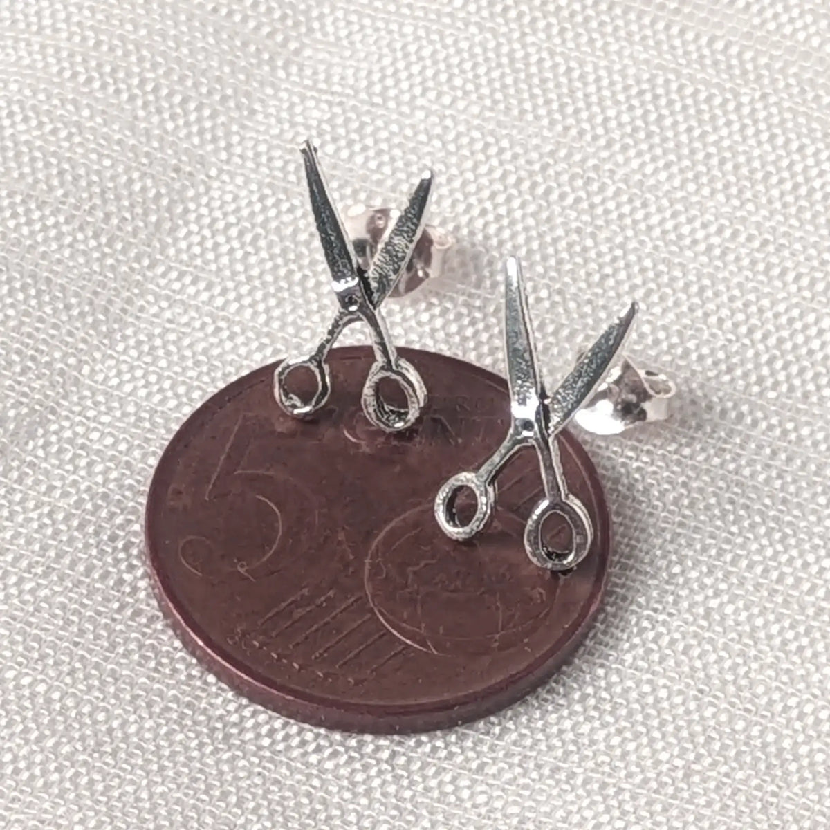 Filigrane Silberohrstecker im Scheren-Design liegend auf einer 5-Cent-Münze für den exakten Größenvergleich.