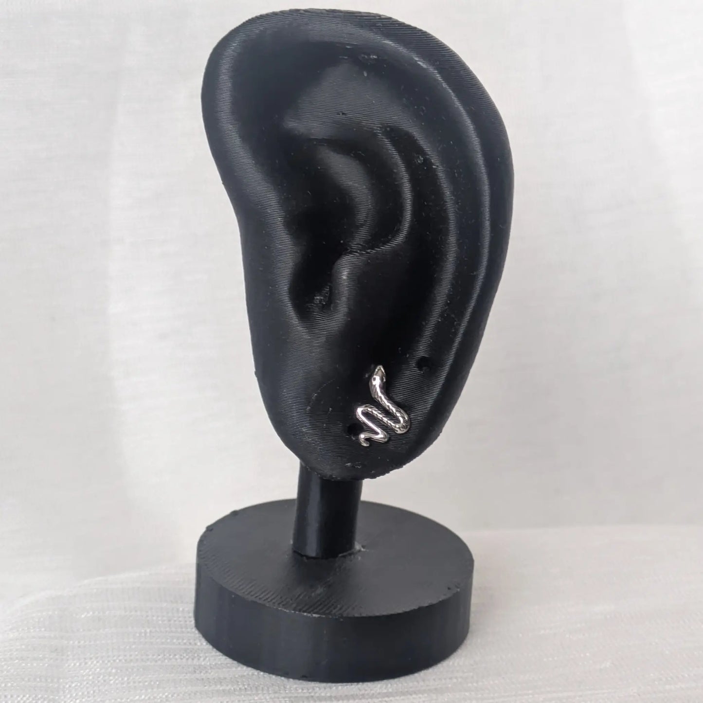 Schlangen Ohrstecker aus 925 Silber präsentiert an einem schwarzen Ohr-Modell