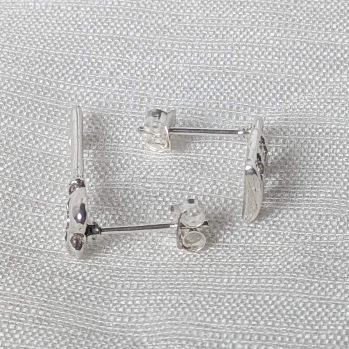 Seitenansicht der asymmetrischen Silber-Ohrstecker zur Veranschaulichung des angelöteten Stifts für einen sicheren Halt.