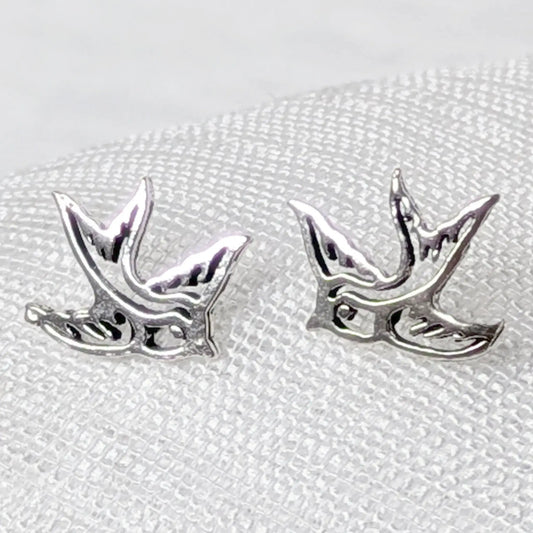 Nahaufnahme von filigranen Schwalben-Ohrsteckern aus 925 Sterling Silber mit Cut-Out-Details.
