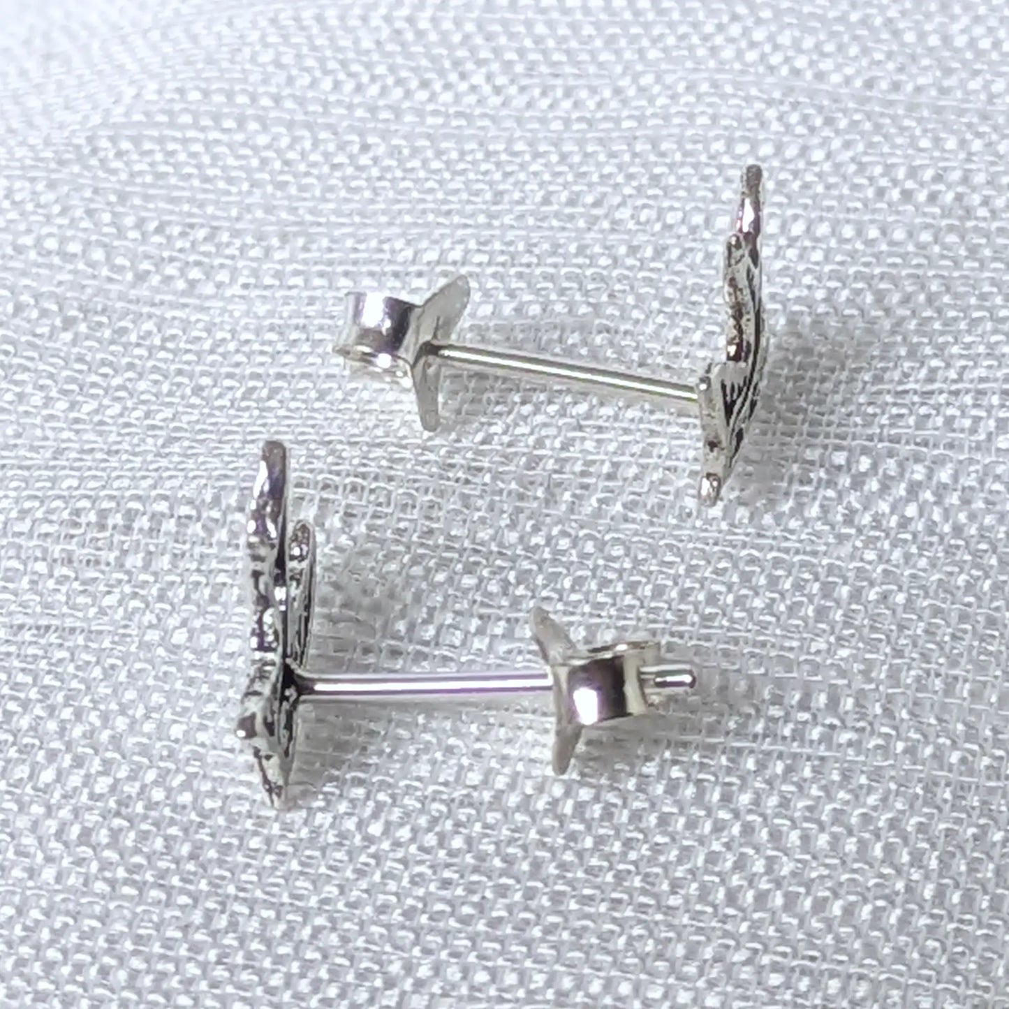 Seitenansicht der flachen Schwalben-Ohrstecker aus feinem 925 Silber am Ohrläppchen.