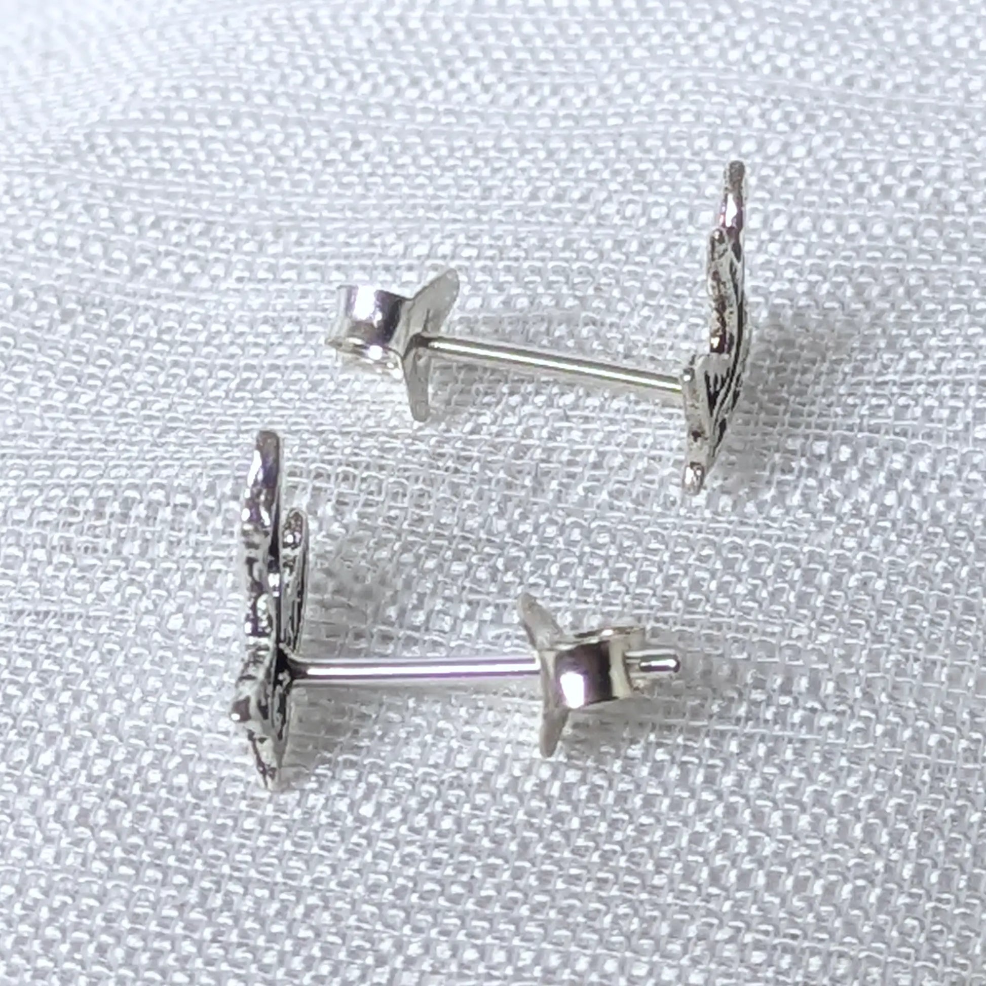 Seitenansicht der flachen Schwalben-Ohrstecker aus feinem 925 Silber am Ohrläppchen.