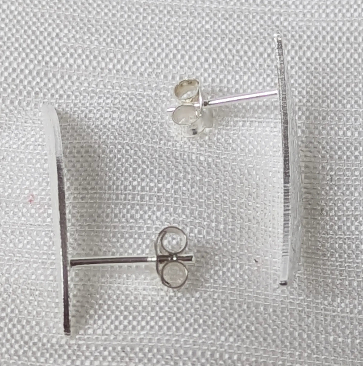 Seitenansicht der gebogenen Silberohrringe zeigt flaches und ergonomisches Design am Ohr