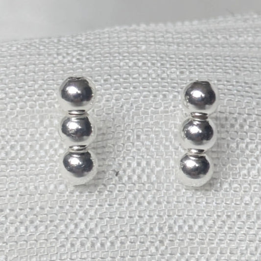 Nahaufnahme 925 Silber Ohrstecker mit drei glänzenden Kugeln.