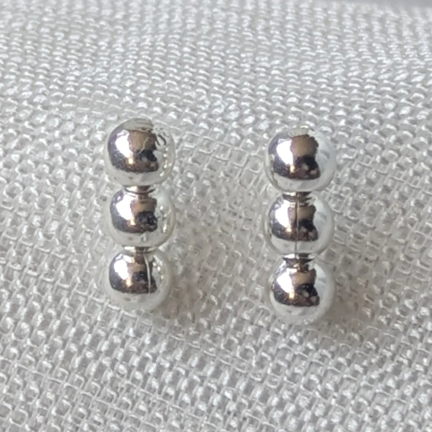 Nahaufnahme 925 Silber Ohrstecker mit drei glänzenden Kugeln.