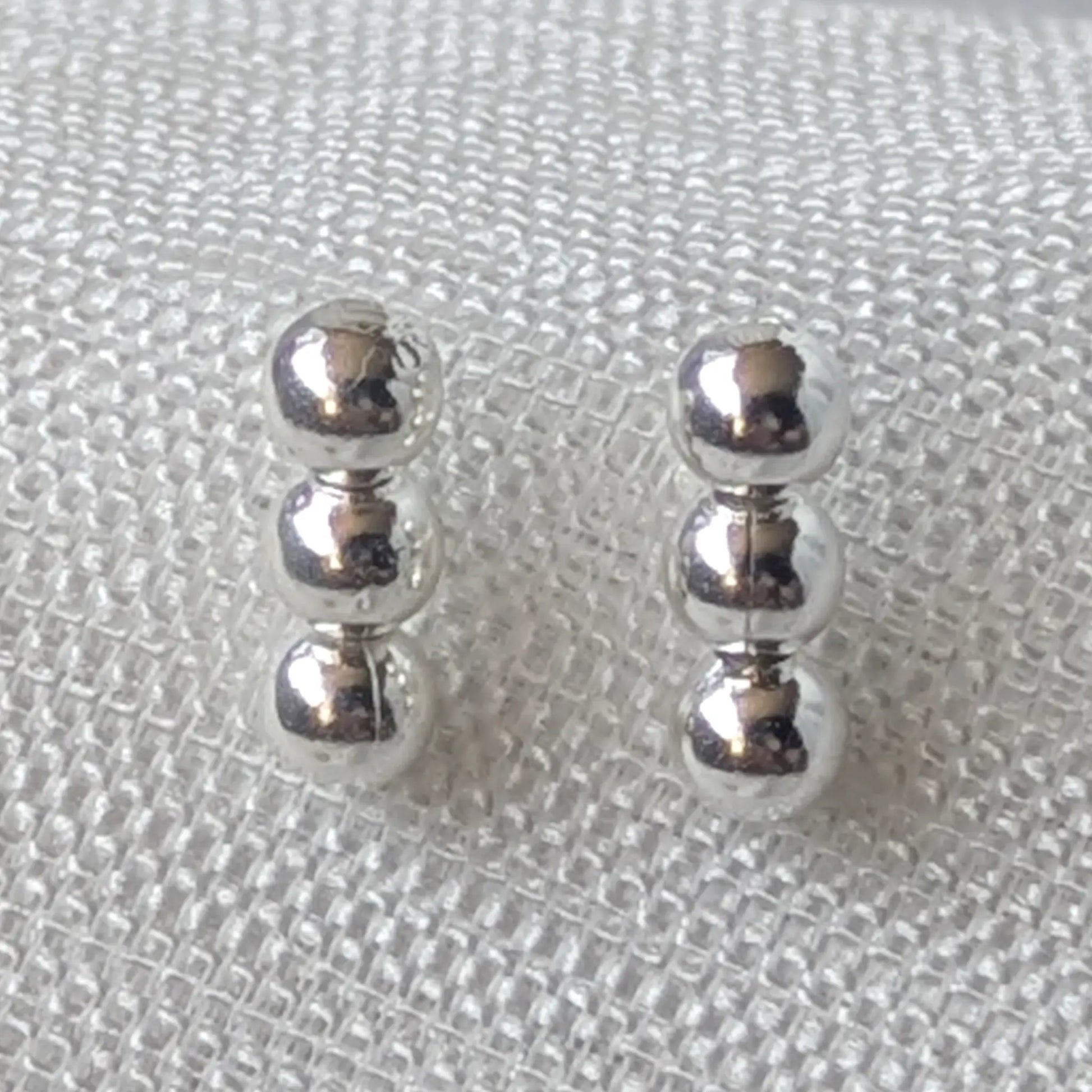 Nahaufnahme 925 Silber Ohrstecker mit drei glänzenden Kugeln.