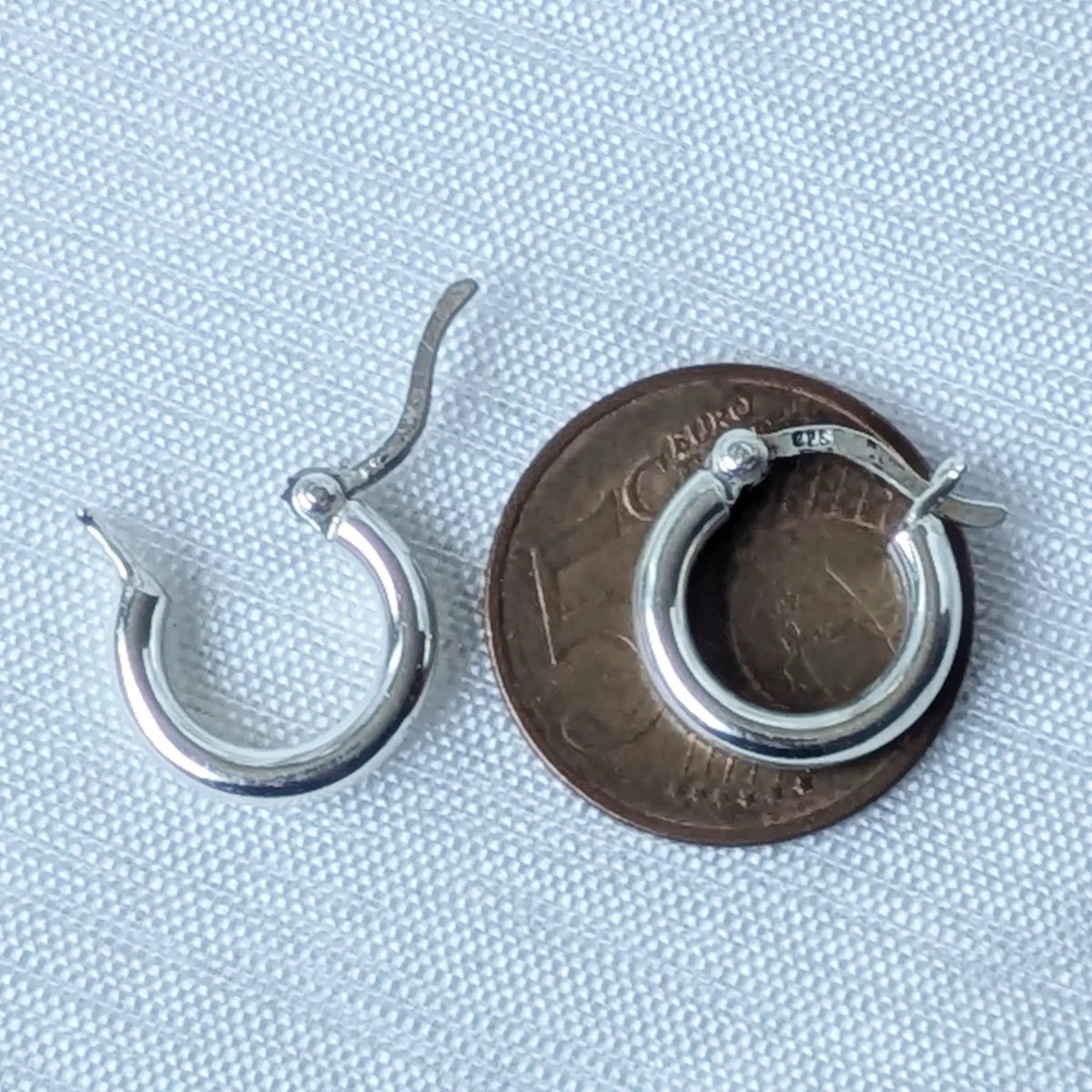 Eine markante, 3mm dicke Silbercreole mit 10mm Durchmesser, elegant und auffällig an einem schwarzen 3D-Ohr-Display präsentiert.