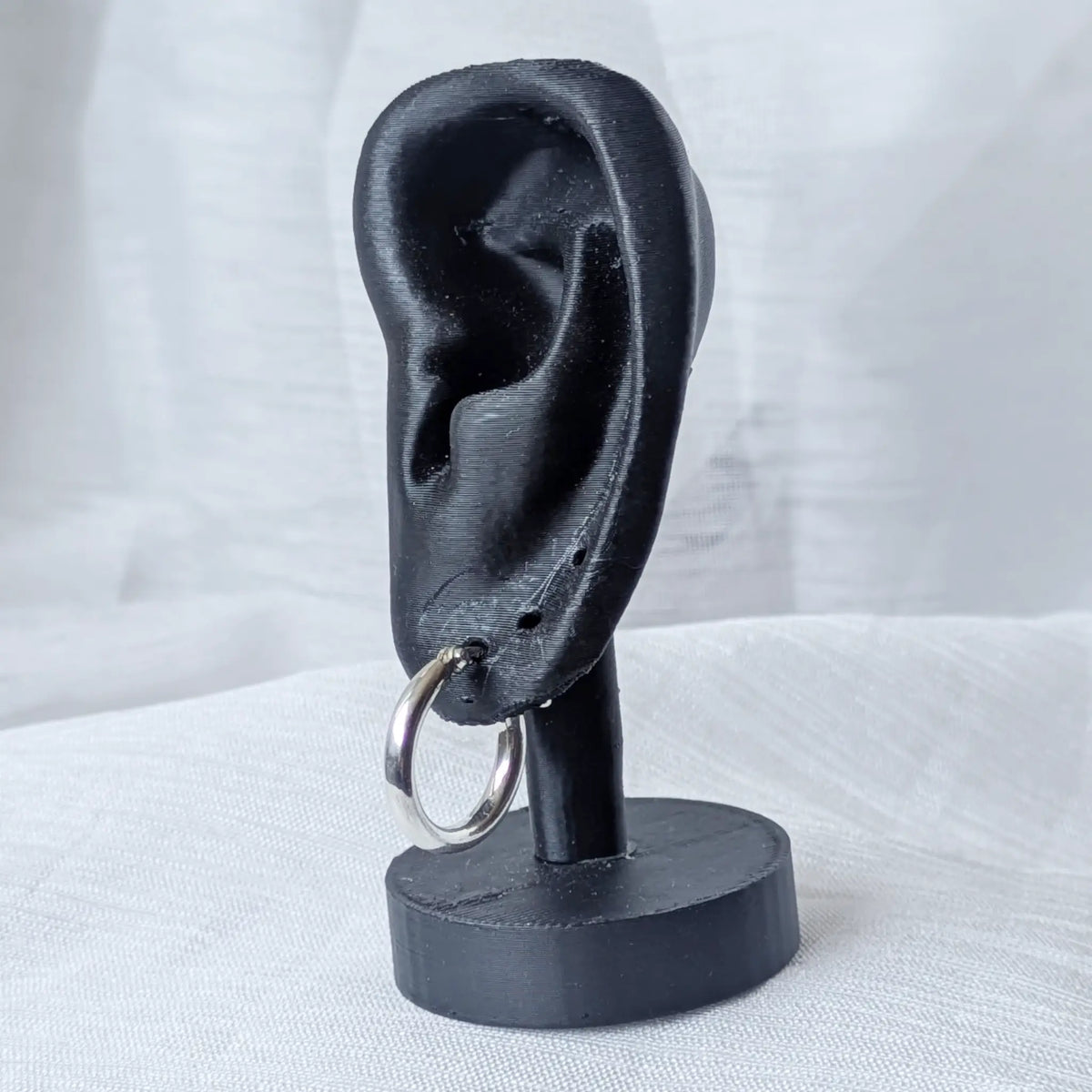 Eine markante, 3mm dicke Silbercreole, Durchmesser 18mm, elegant und auffällig an einem schwarzen 3D-Ohr-Display präsentiert.