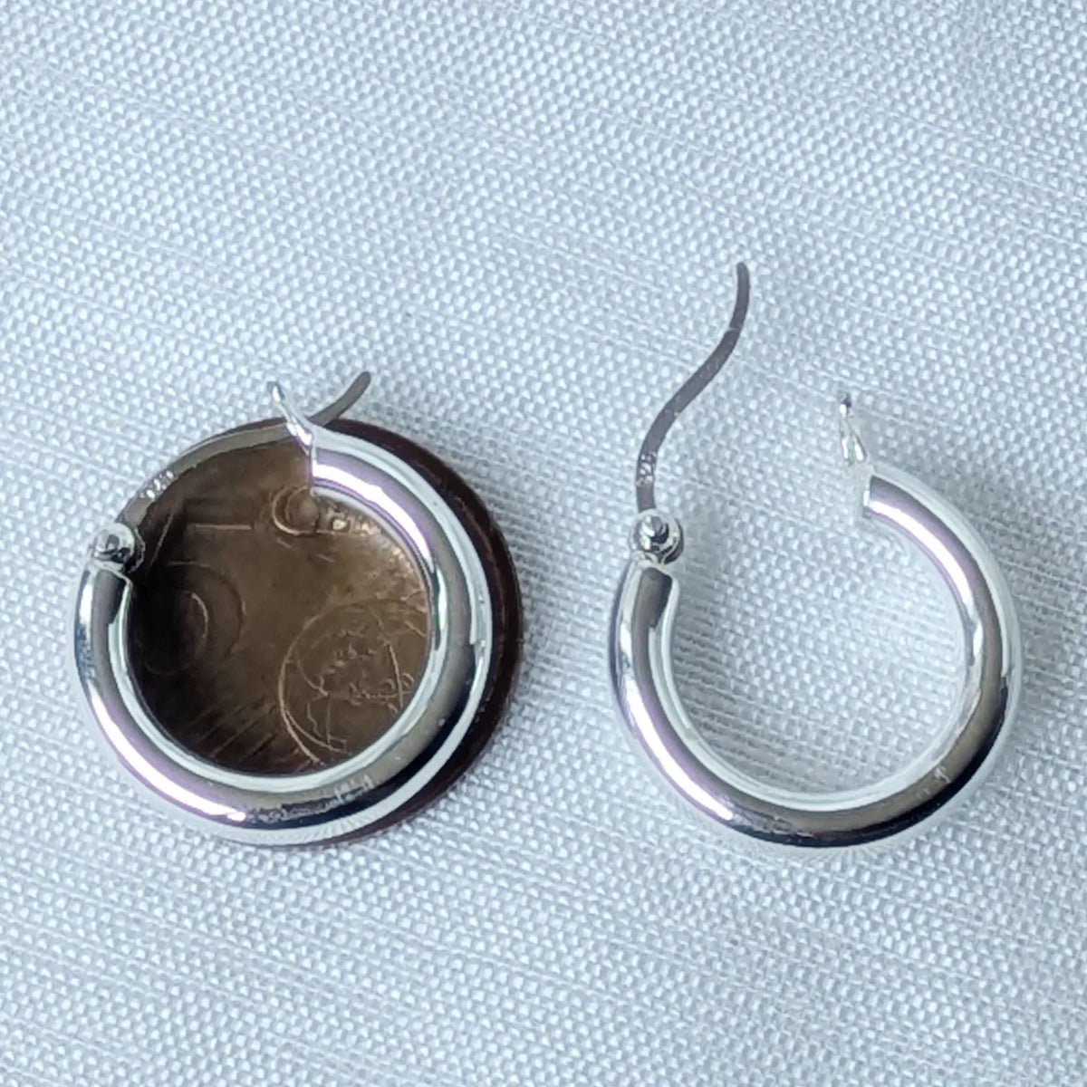 Eine markante, 3mm dicke Silbercreole mit 20mm Durchmesser, elegant und auffällig an einem schwarzen 3D-Ohr-Display präsentiert.